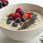 A bowl of oatmeal topped with blueberries, raspberries, strawberries, and chia seeds.